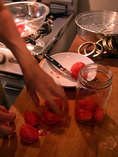 Quartering peeled tomatoes in prep for adding to jar